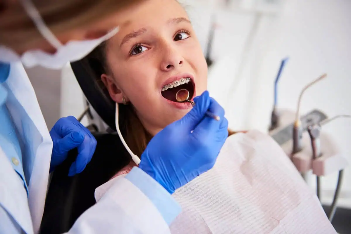 Orthodontist gently examining a child's teeth